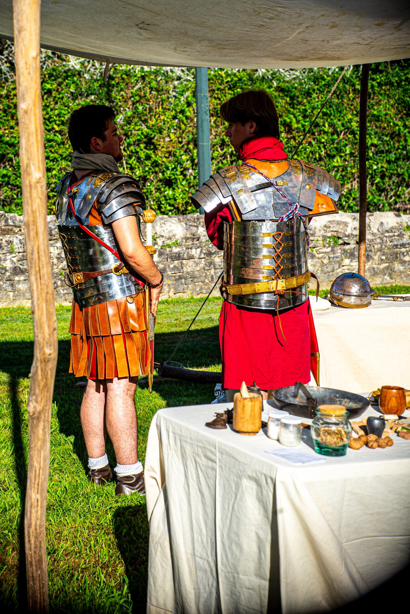 Bannière de fond : deux membres de la Legio XX Valeria Victrix en tenue romaine discutant lors d'un évènement